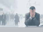 Muted digital illustration of a distressed man in a suit sitting with his head in his hands at an airport, blurred travelers passing behind him.