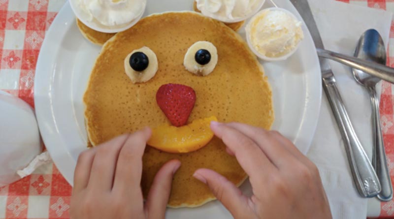 Iden Elliott adjusts a smiley face on pancakes at Ellen's Danish Pancake House in Buellton, Calif.