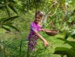 Vicky Tohopu, owner of NIU Shack in Raiatea, collects herbs for her vegan lunch