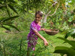 Vicky Tohopu, owner of NIU Shack in Raiatea, collects herbs for her vegan lunch